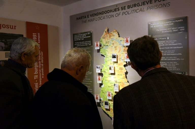 Visitors to a museum in Tirana look at a map showing the location of political prisons during the Communist era