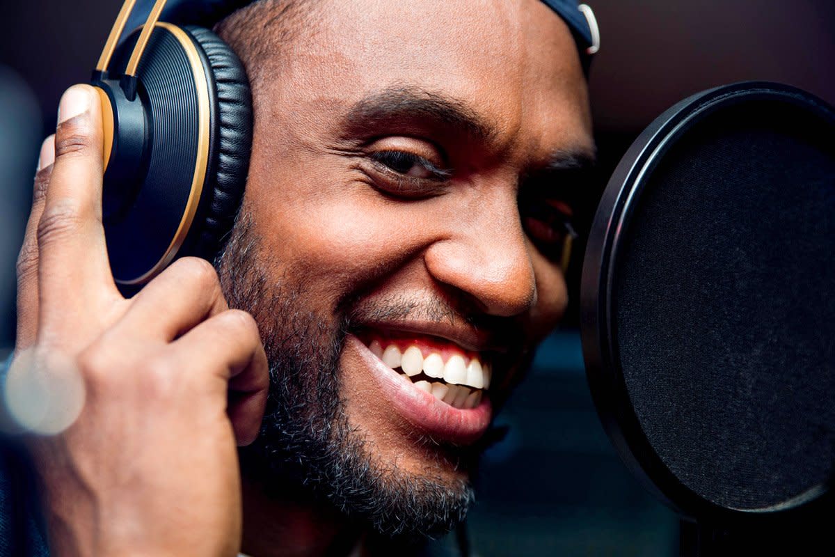 A man records audio at a recording booth.