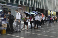 People queue up to buy last issue of Apple Daily at a newspaper booth at a downtown street in Hong Kong, Thursday, June 24, 2021. Hong Kong’s sole remaining pro-democracy newspaper has published its last edition. Apple Daily was forced to shut down Thursday after five editors and executives were arrested and millions of dollars in its assets were frozen as part of China’s increasing crackdown on dissent in the semi-autonomous city. (AP Photo/Vincent Yu)