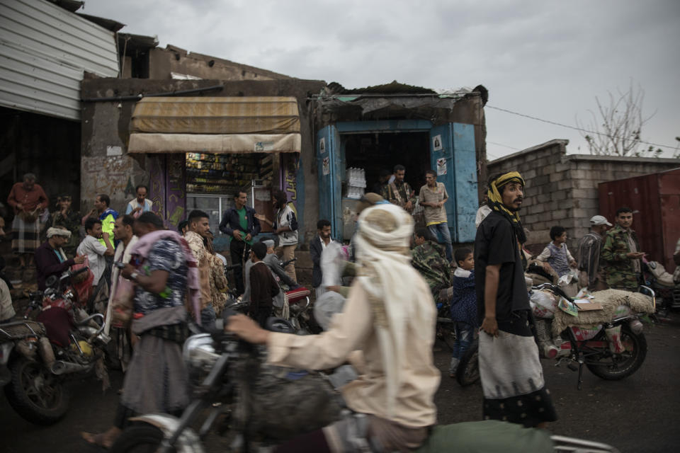 In this Aug. 4, 2019 photo, people gather at a market in Dhale province, in Yemen. The area is one of the stops where Ethiopian migrants take shelter to continue their journey to Saudi Arabia, and an active frontline between militiamen backed by the Saudi-led coalition and Houthi rebels only a few hundred meters away. (AP Photo/Nariman El-Mofty)