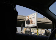 A woman wearing a "Niqab" drives past a billboard displaying an advert for Saudi Arabia's state-owned oil giant Aramco with Arabic reading "Saudi Aramco, soon on stock exchange" in Jiddah, Saudi Arabia, Tuesday, Nov. 12, 2019. Saudi Aramco is the kingdom's oil and gas producer, pumping more than 10 million barrels of crude oil a day, or some 10% of global demand. (AP Photo/Amr Nabil)