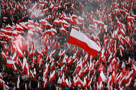 People carry Polish flags and flares during a march organised by officials together with far right, nationalist groups marking the 100th anniversary of Polish independence in Warsaw, Poland November 11, 2018. REUTERS/Kacper Pempel