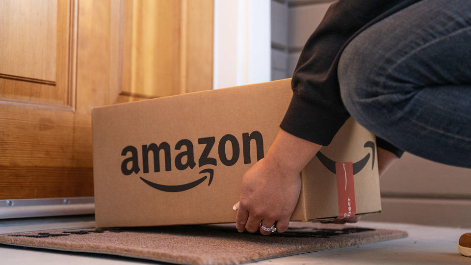 Person placing an Amazon box on a doorstep