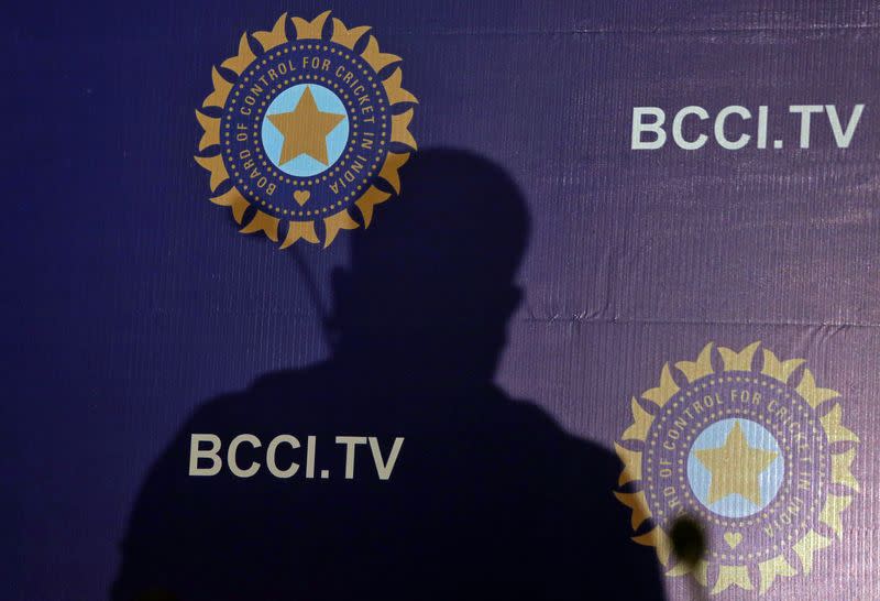 The shadow of a man falls on a backdrop with the logo of the India's cricket board BCCI before the start of a news conference to announce its cricket team's coach, in Mumbai,