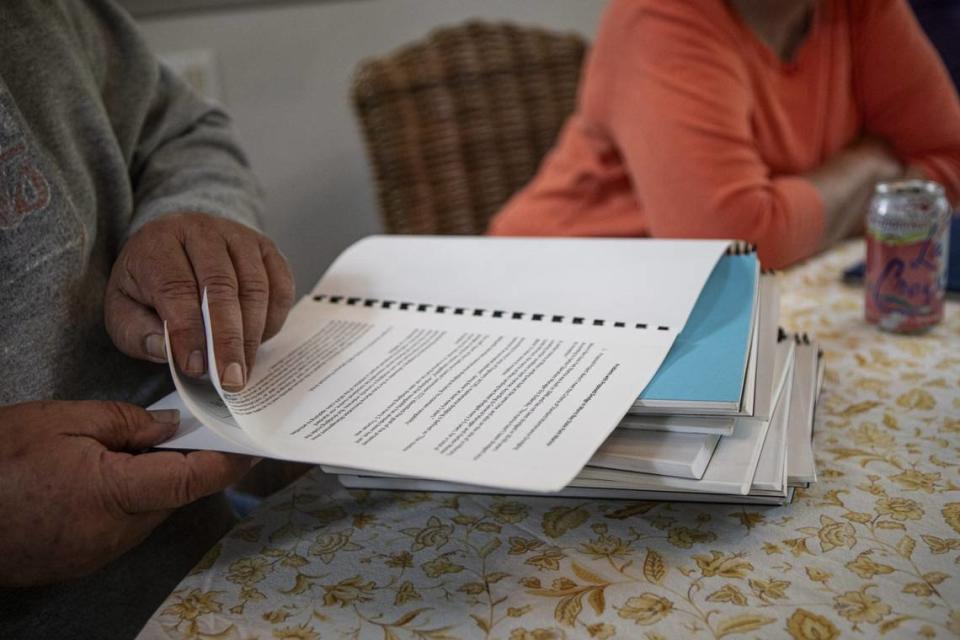 Los Osos resident Joey Racano leafs through reports at a meeting of neighbors concerned about offshore wind projects.