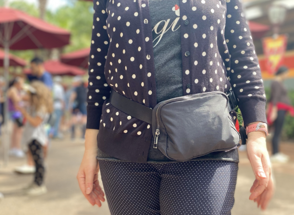 Black belt bag on a person wearing a polka dot cardigan