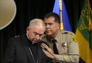 Los Angeles County Sheriff Robert Luna, right, hugs Archbishop of Los Angeles, Jose H. Gomez as he pauses in silence during a news conference announcing an arrest has been made in connection to the murder of Catholic auxiliary bishop David O'Connell, who was fatally shot over the weekend in Hacienda Heights, at a news conference at the Hall of Justice Monday, Feb. 20, 2023 in Los Angeles. Luna says a SWAT team arrested Carlos Medina in the morning at his home in Torrance, about 35 miles (56 kilometers), southwest of Hacienda Heights, where Auxiliary Bishop David O'Connell was killed. (AP Photo/Damian Dovarganes)