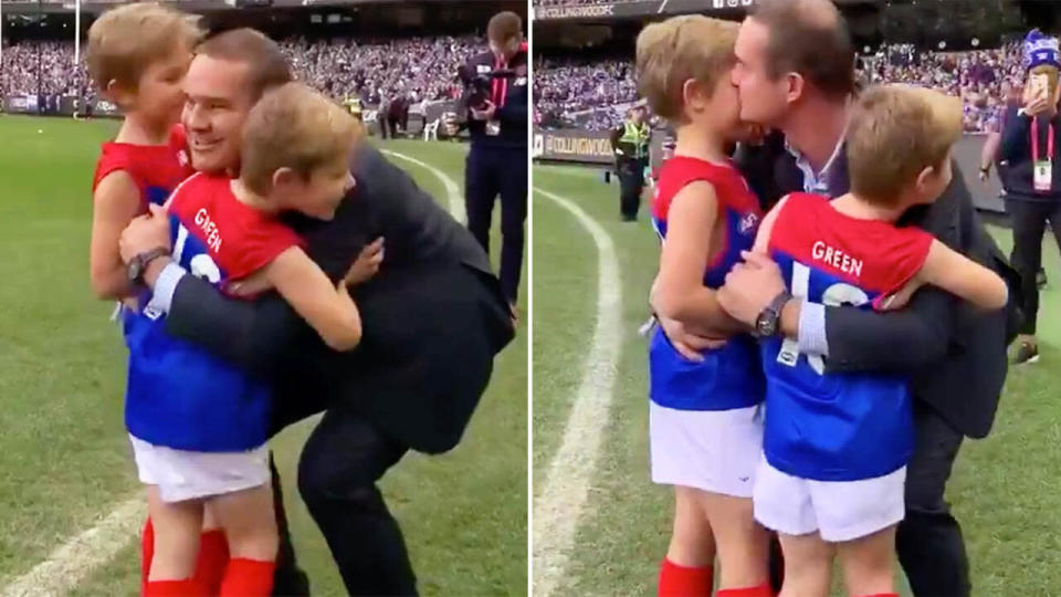 Former Melbourne Demons star Brad Green embraces his sons Oliver and Wilba after they joined the team as they ran through the banner. Green's wife Anna tragically passed away late in May. Picture: 7AFL