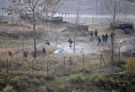 Army soldiers search for suspected militants as smoke rises from a bunker after a gunbattle in Mohra in Uri December 5, 2014. REUTERS/Danish Ismail