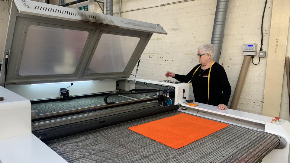 Woman cutting fabric in factory