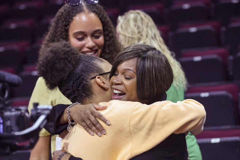 Coquese Washington, right, is embraced by her former player, Olivia Miles of Notre Dame, during a news conference to introduce Washington as the new women's basketball coach at Rutgers on Tuesday, May 24, 2022 in Piscataway, N.J. Washington was the associate head coach at Notre Dame for two seasons before being hired by Rutgers this week. (Andrew Mills/NJ Advance Media via AP)