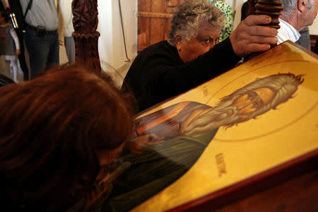 Pilgrims kiss Greek Orthodox icons in the Church of the Monastery of Apostolos Andreas in north-eastern Cyprus after the structure was reopened after two years of renovation, Cyprus November 7, 2016. REUTERS/Yiannis Kourtoglou