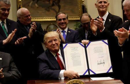 U.S. President Donald Trump smiles after signing S.544, the Veterans Choice Program Extension and Improvement Act, at the White House in Washington, U.S., April 19, 2017. REUTERS/Kevin Lamarque