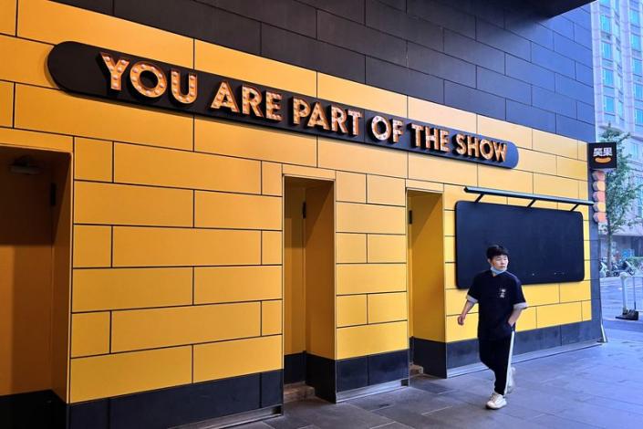 A person walks past a show venue of stand-up comedy company Xiaoguo Culture Media Co that has closed its business, in Beijing