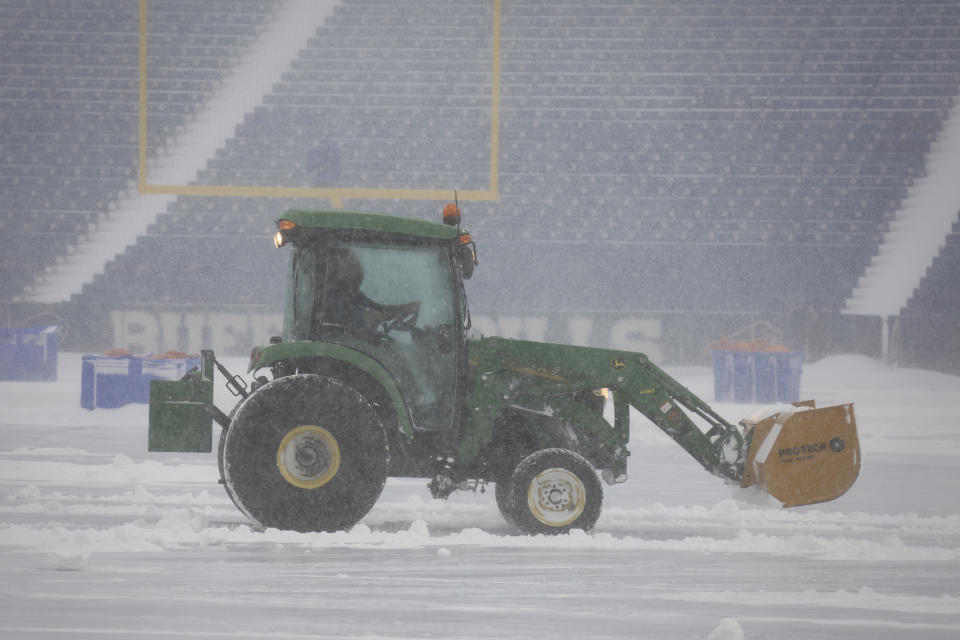 Trabajadores retiran la nieve del Estadio Highmark de Orchard Park, Nueva York., el domingo 14 de enero de 2024. (AP Foto/ Jeffrey T. Barnes)