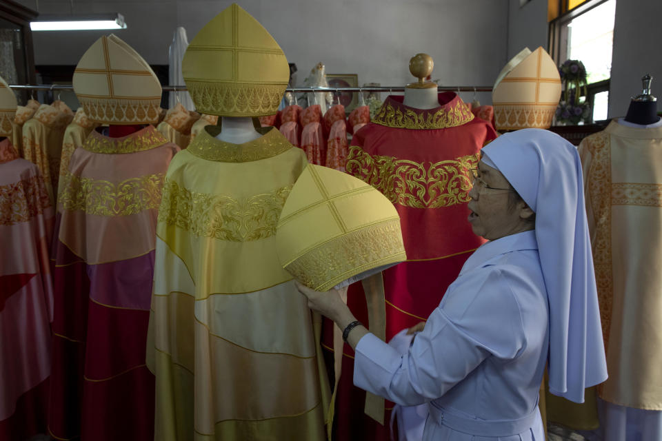 In this Friday, Nov. 8, 2019, photo, Sister Sukanya Sukchai holds a newly made Thai silk miter at Catholic preparatory school in Bangkok, Thailand. Seamstresses from the Congregation of the Sacred Heart of Jesus Sisters of Bangkok are studiously snipping and sewing, fashioning robes for the upcoming visit of Pope Francis. They’ve been working tirelessly, running up the ceremonial garments Pope Francis will wear during his four-day visit to Thailand later this month. (AP Photo/Gemunu Amarasinghe)