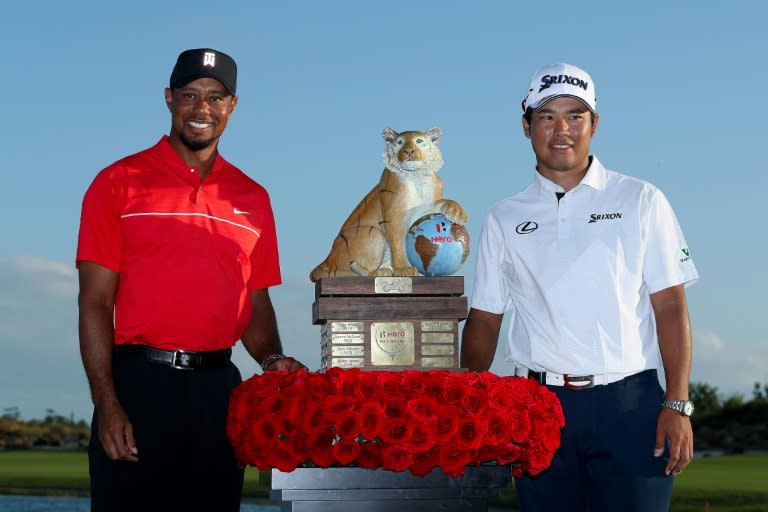 Hideki Matsuyama (R) of Japan poses with the trophy and host Tiger Woods after winning the Hero World Challenge at Albany, The Bahamas on December 4, 2016