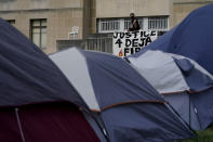 A protester watches during a news conference outside city hall Thursday, Oct. 8, 2020, in Kansas City, Mo. Protesters have occupied the lawn and plaza in front of city hall for more than a week demanding the resignation of police chief Rick Smith and an officer who knelt on the back of a nine-month pregnant woman while arresting her last week. (AP Photo/Charlie Riedel)