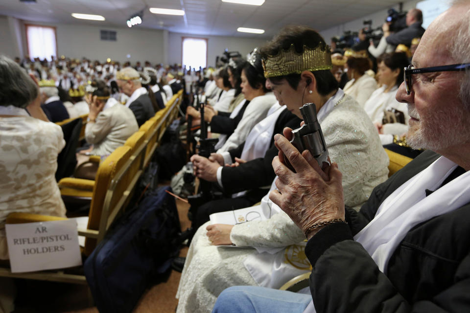 A man holds an unloaded weapon during services at the World Peace and Unification Sanctuary in Newfoundland, Pennsylvania. - Credit: Jacqueline Larma/AP Images