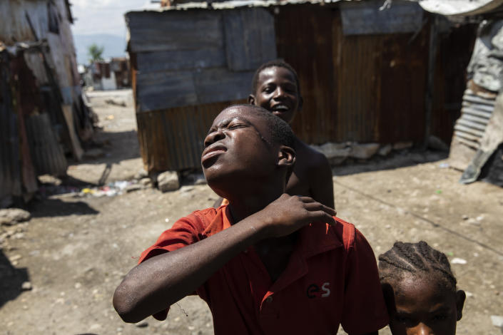A boy describes the extreme poverty he faces daily, in the Cite Soleil shanty town of Port-au-Prince, Haiti, Friday, Oct. 1, 2021. (AP Photo/Rodrigo Abd)