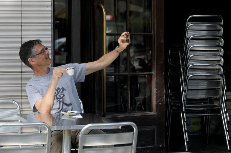 Un hombre haciéndose un selfie en el Café Zurich de Plaza Catalunya, en Barcelona España