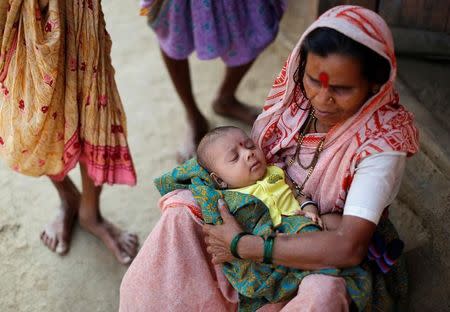 Uma Sitaramtupange, 65, who studies at Aajibaichi Shaala (Grandmothers' School), holds a baby outside her house in Fangane village, India, February 15, 2017. REUTERS/Danish Siddiqui