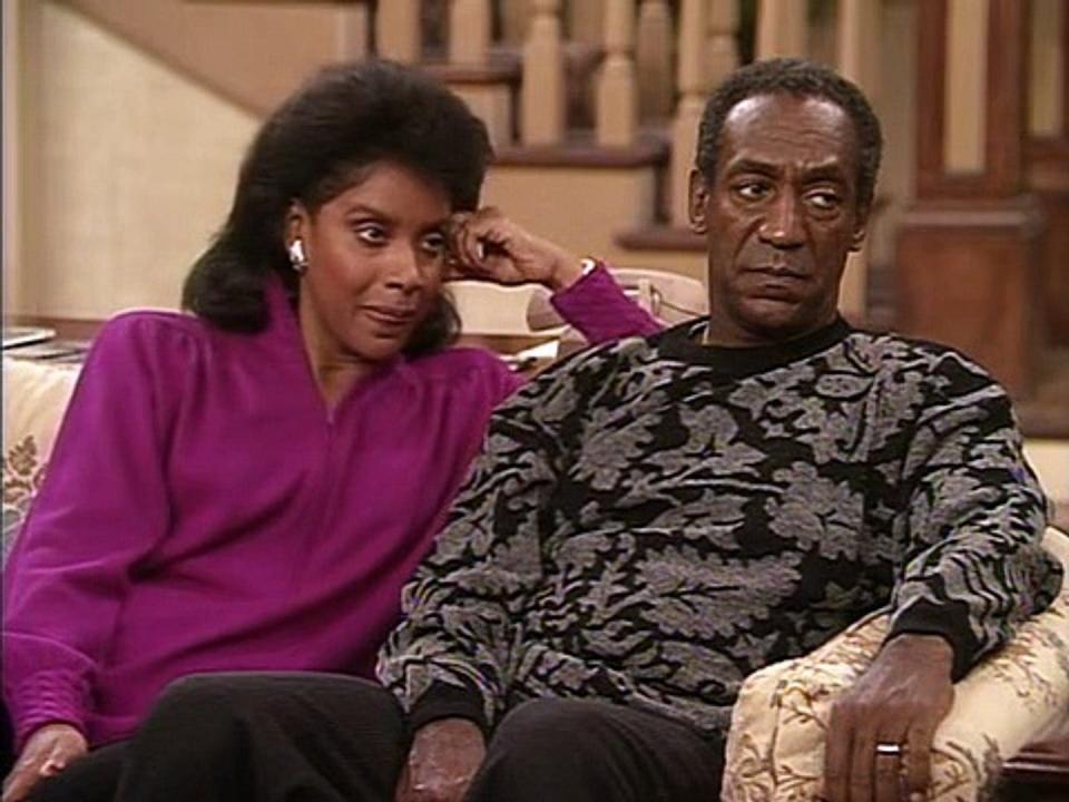 Phylicia Rashad and Bill Cosby sitting on a couch