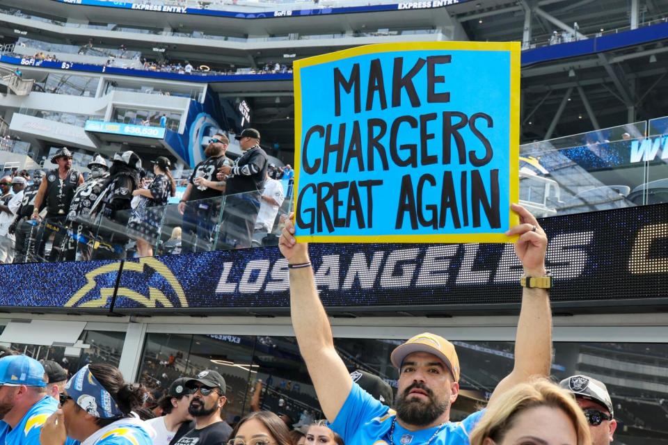 A Chargers fan holds up a sign saying, "Make Chargers Great Again."