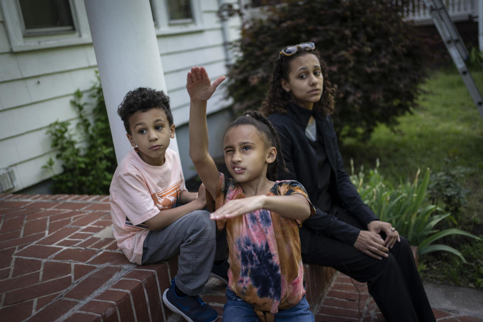 Catherine Manson sits on the front porch with her children, Caydence Manson and Carter Manson, in Hartford, Conn., on Wednesday, May 25, 2022. The prevalence of asthma in the Connecticut public school system has slightly decreased over time but 25,576 students have asthma, or about 1 in 8, including Caydence and Carter. But the incidence among Black students is about 50% higher. (AP Photo/Wong Maye-E)