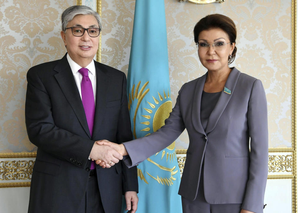 FILE - Kazakhstan's interim president Kassym-Jomart Tokayev and Dariga Nazarbayeva, daughter of Kazakhstan's former president Nursultan Nazarbayev, shake hands in Nur-Sultan, Kazakhstan, on Wednesday, March 20, 2019. British authorities issued "unexplained-wealth orders" to Nazarbayev's daughter and grandson demanding they reveal where they obtained funds for three London properties worth more than 80 million pounds. (Kazakhstan's Presidential Press Service via AP)