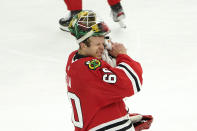 Chicago Blackhawks goaltender Collin Delia wipes his face during a break in the action in the second period of an NHL hockey game against the Dallas Stars Monday, May 10, 2021, in Chicago. (AP Photo/Charles Rex Arbogast)