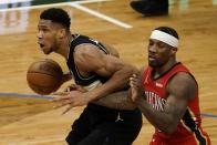 Milwaukee Bucks' Giannis Antetokounmpo drives past New Orleans Pelicans' Eric Bledsoe during the second half of an NBA basketball game Thursday, Feb. 25, 2021, in Milwaukee. (AP Photo/Morry Gash)