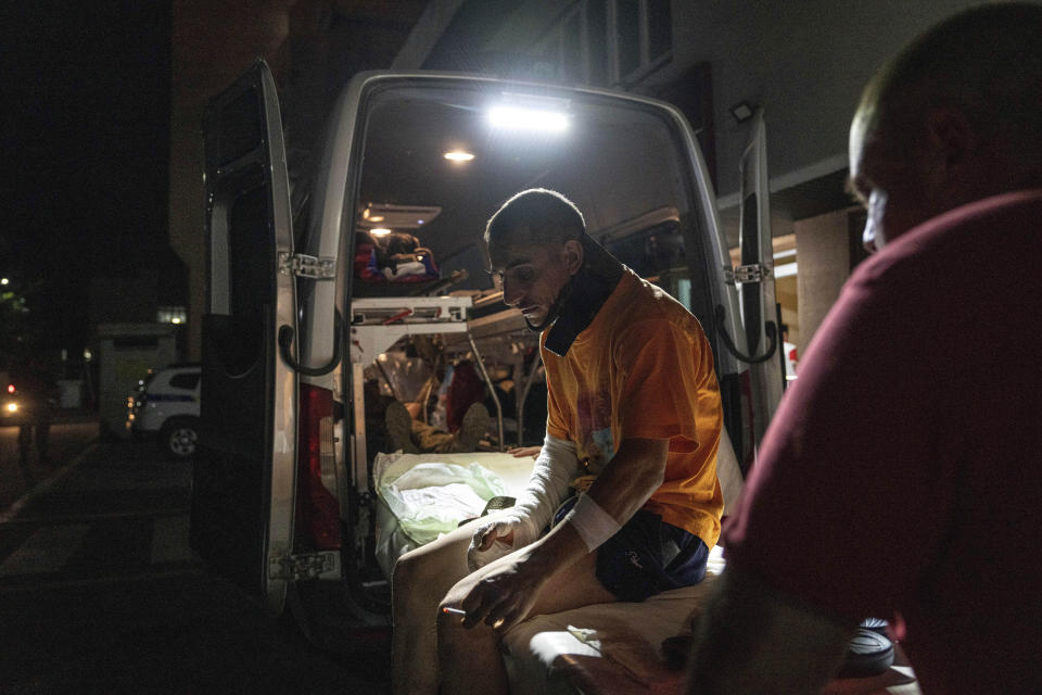 A wounded Ukrainian serviceman smokes a cigarette outside an ambulance at Mechnikov Hospital in Dnipro, Ukraine, Friday, July 14, 2023. A surge of wounded soldiers has coincided with the major counteroffensive Ukraine launched last month to try to recapture its land from Russian forces. Surgeons at the Mechnikov Hospital, one of the country's biggest, are busier now than perhaps at any other time since Russia began its invasion 17 months ago. (AP Photo/Evgeniy Maloletka)