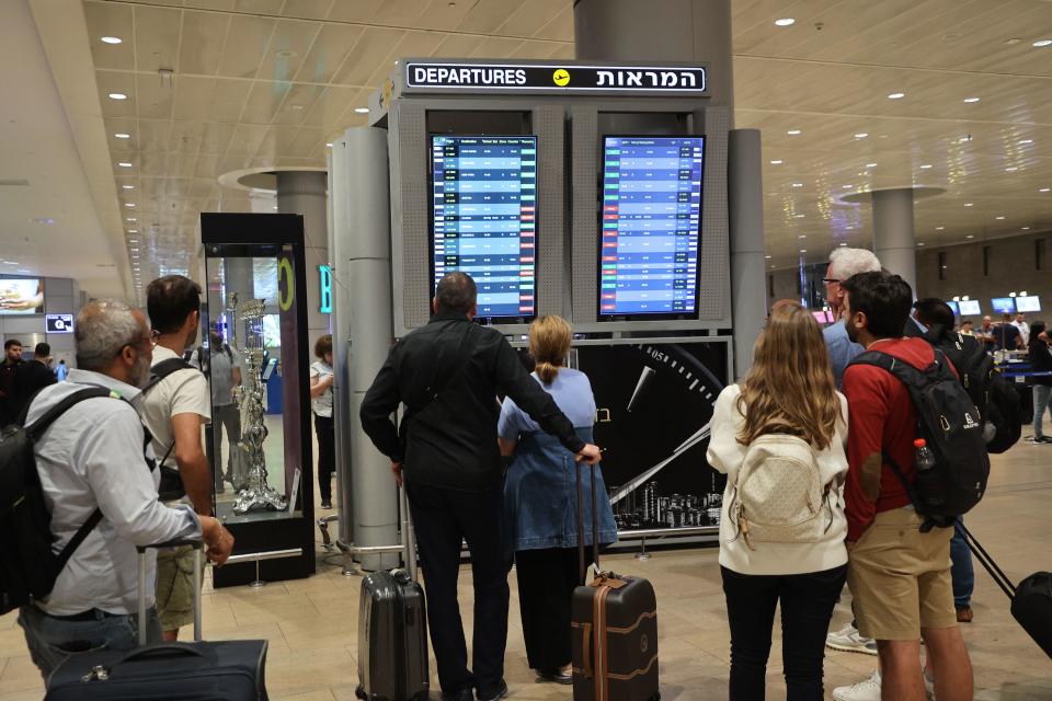 Passengers look at a departure board at Ben Gurion Airport near Tel Aviv, Israel, on Oct. 7, 2023, as flights are canceled because of the Hamas surprise attacks.  / Credit: GIL COHEN-MAGEN/AFP via Getty Images