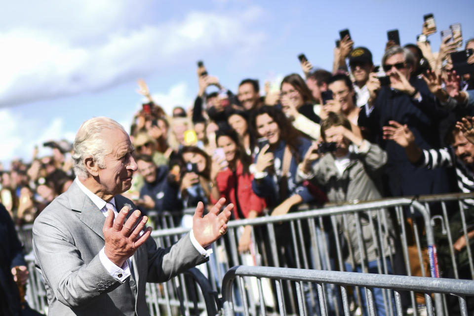 King Charles III gestures to the crowd before attending celebrations of British and French culture and business at Place de la Bourse in Bordeaux, southwestern France, Friday Sept. 22, 2023. Britain's King Charles III traveled to Bordeaux on the third day of his state visit to France to focus on climate and the environment. (Christophe Archambault, Pool via AP)