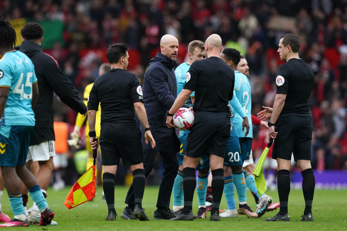 Manchester United manager Erik ten Hag (centre) speaks to referee Anthony Taylor during the Premier League match at Old Trafford, Manchester. Picture date: Sunday March 12, 2023. (PA Wire)