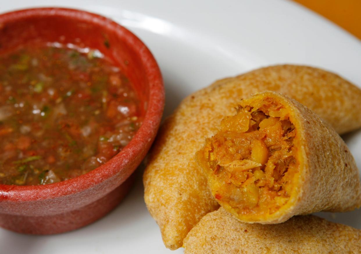 Crispy, Colombian-style empanadas are on the menu at El Sabor Latino restaurants in Palm Beach Gardens, Greenacres and Boynton Beach. They are served with a mildly spicy ají sauce.