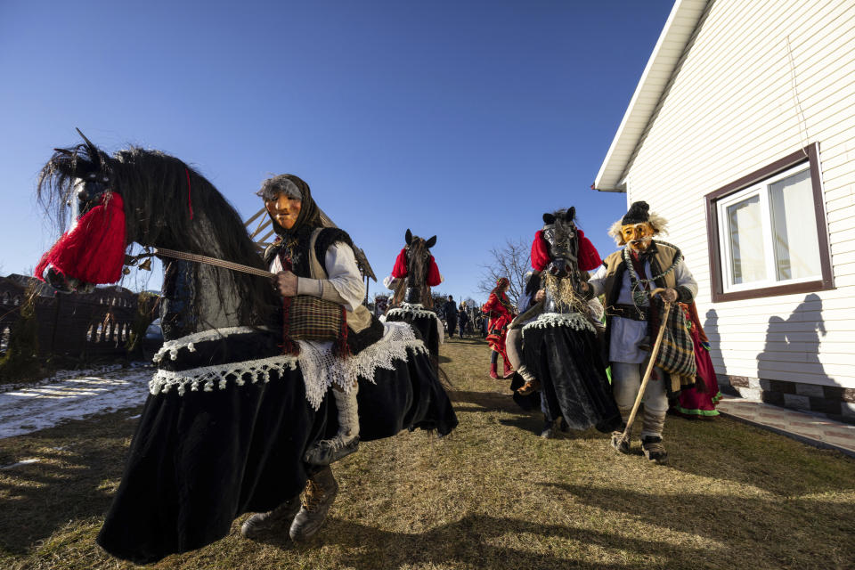 Participants dressed in traditional costumes, celebrate the Malanka festival in the village of Krasnoilsk, Ukraine, Friday, Jan. 14, 2022. (AP Photo/Ethan Swope)