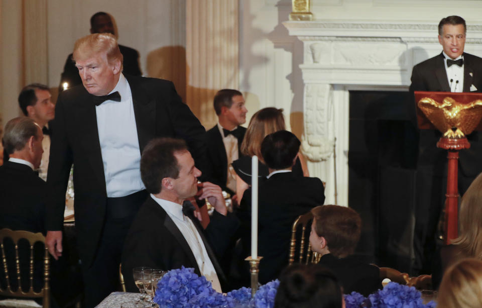 FILE - In this Feb. 25, 2018, file photo, President Donald Trump, left, pats the shoulder of Montana Gov. Steve Bullock as he walks to his seat at the Governors' Ball in the State Dining Room of the White House in Washington. A federal judge in Montana on Wednesday, Sept. 30, 2020, has rejected an effort by the campaign of President Donald Trump and Republican groups to block Montana counties from holding mostly-by-mail elections this November, saying the campaign's claim that the election may fall prey to widespread voter fraud is "a fiction." (AP Photo/Pablo Martinez Monsivais, File)