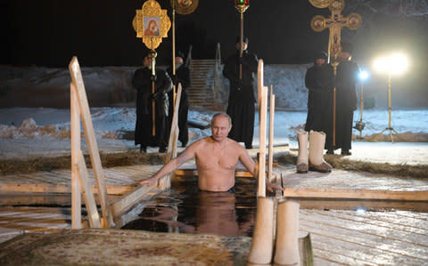 Mr Putin submerges himself in an icy lake as part of a popular Orthodox ritual on Thursday - Credit: Alexei Druzhinin/AFP Photo/Sputnik