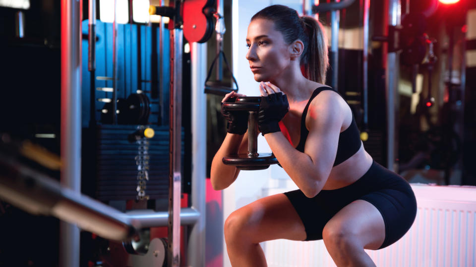 Woman performing goblet squat in gym