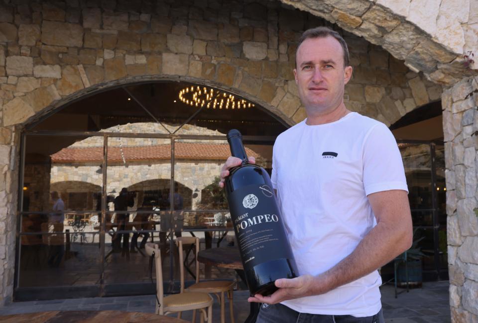 <p>Israeli winemaker Yaakov Berg's holds a bottle of his red blend named after Pompeo at the Psagot Winery </p>AFP via Getty Images