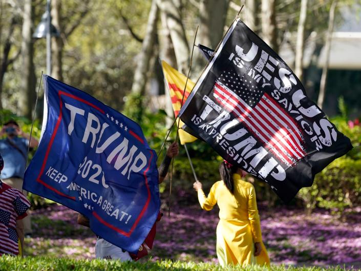 Former President Donald Trump supporters wave flags outside the convention center at the Conservative Political Action Conference (CPAC) Sunday, Feb. 28, 2021, in Orlando, Fla.