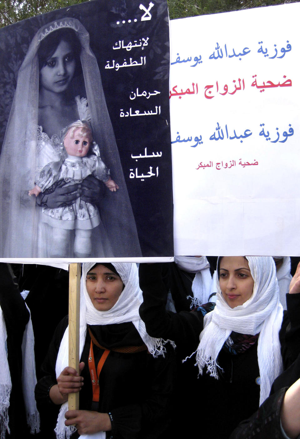 FILE - In this Tuesday, March 23, 2010 file photo, Yemeni school students hold up posters denouncing child marriage, as they take part in a protest outside the parliament in Sanaa, Yemen. In the Middle East, Saudi Arabia and Yemen are the only Arab countries that do not have laws that set a minimum age for marriage. According to a December 2011 Human Rights Watch report, approximately 14 percent of girls in the Arab world’s poorest nation of Yemen were married before the age 15, and 52 percent were married before 18 years old. Arabic reads, "no for killing childhood " and "Fawzya Abdullah: a victim of underage marriage." (AP Photo, File)