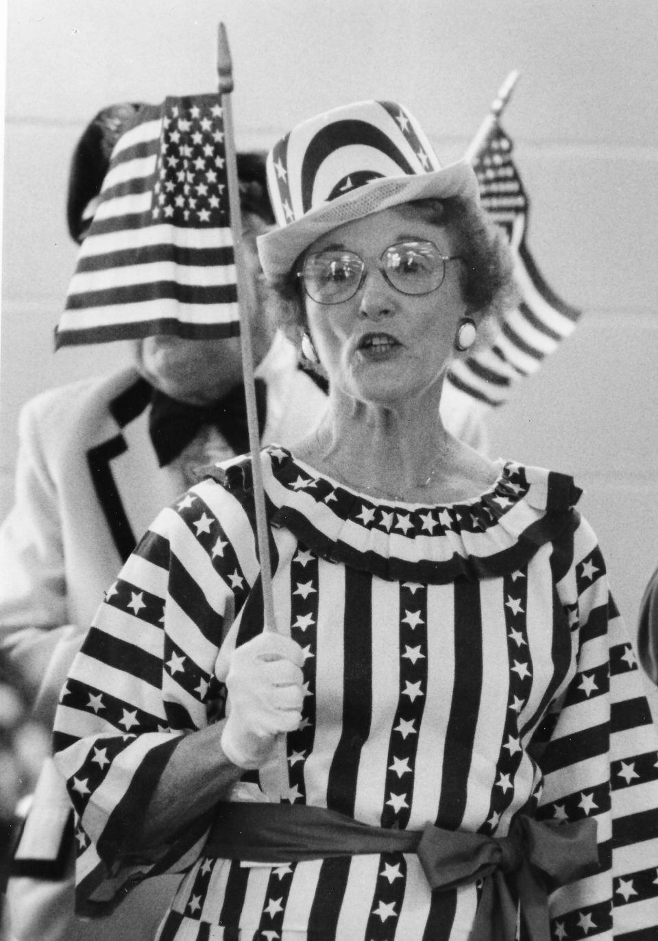 Florence Cummins waves a flag while performing with the Patterson Park Singin' Seniors on Oct. 21, 1991, at the dedication of a 2,775-square-foot addition at the community center on North Hill in Akron.