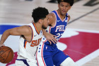 Phoenix Suns guard Devin Booker (1) tries to get by Philadelphia 76ers guard Matisse Thybulle (22) during the second half of an NBA basketball game Tuesday, Aug. 11, 2020, in Lake Buena Vista, Fla. (AP Photo/Ashley Landis, Pool)