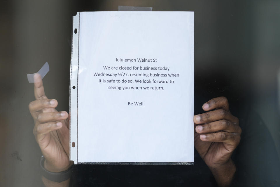 A worker posts a sign on the door of a ransacked Lululemon store in Philadelphia, Wednesday, Sept. 27, 2023. Police say groups of teenagers swarmed into stores across Philadelphia in an apparently coordinated effort, stuffed bags with merchandise and fled. (AP Photo/Matt Rourke)