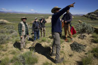 Bradley University professor Anant Deshwal points to cliffs where golden eagles are nesting in Cody, Wyo., on Wednesday, June 15, 2022. He and a team of scientists, including Charles Preston, are monitoring golden eagle populations in their natural habitat the U.S. West. Nationally, the species is teetering on the edge of decline. (AP Photo/Emma H. Tobin)