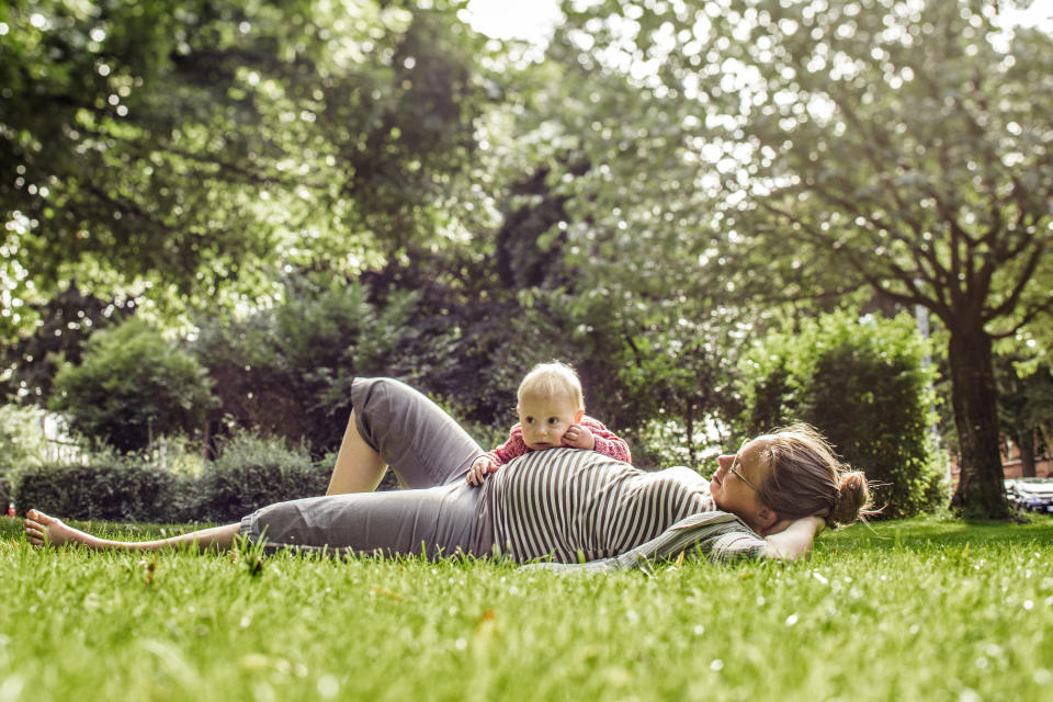 A pregnant woman bonding with her baby son in a park in the city. (Getty Images)