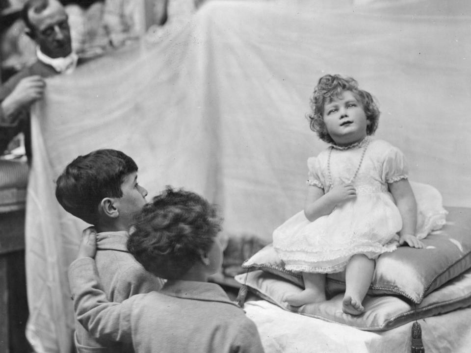 20th June 1928: Two young boys stare at a waxwork model of Princess Elizabeth at Madame Tussaud's waxworks in London.